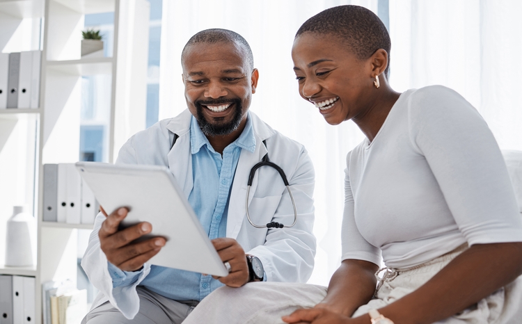 Male doctor shows female patient notes on a tablet
