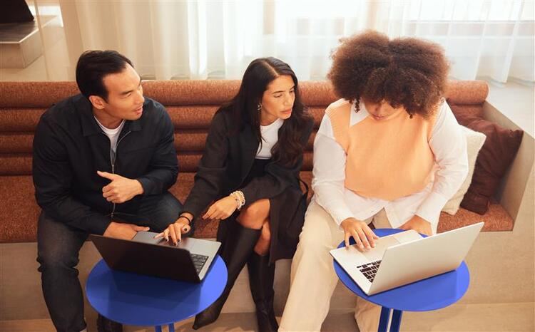 Three people studying on a laptop