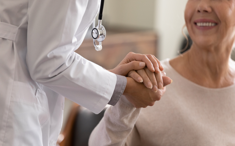 Doctor holds the hand of a female cancer patient