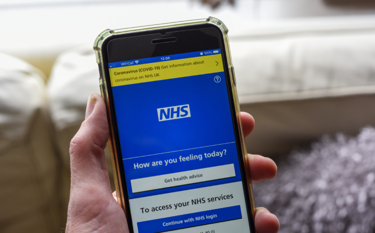 A phone displaying the NHS App